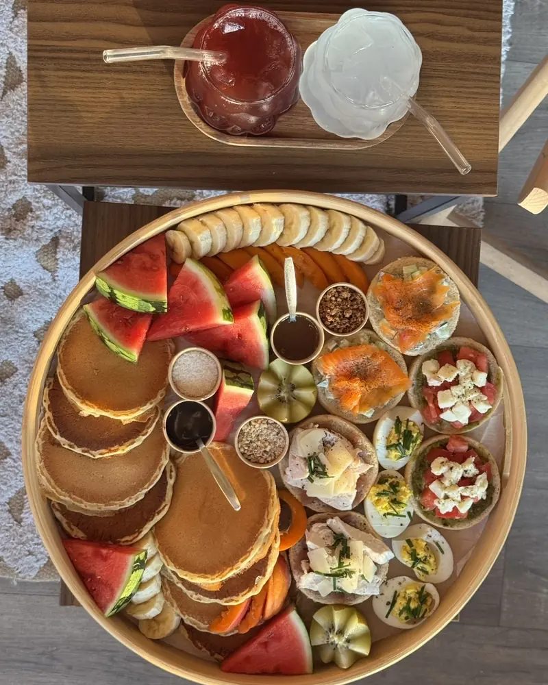 Plateau rond de brunch : pancakes, fruits frais, toasts salés, œufs, coulis et toppings