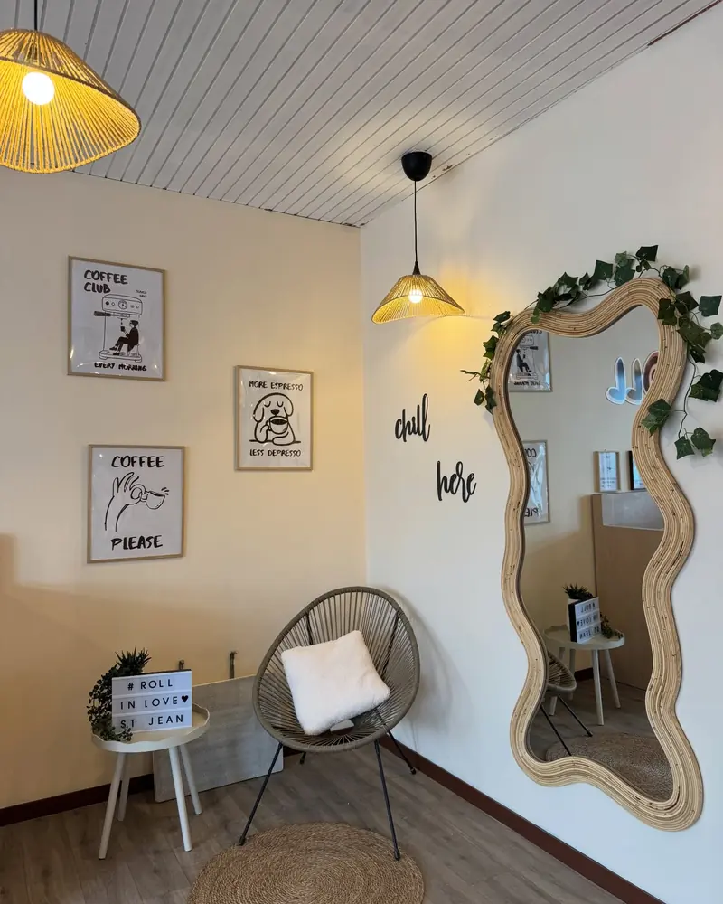 Coin lecture avec miroir ondulé, chaise en rotin et cadres au mur
