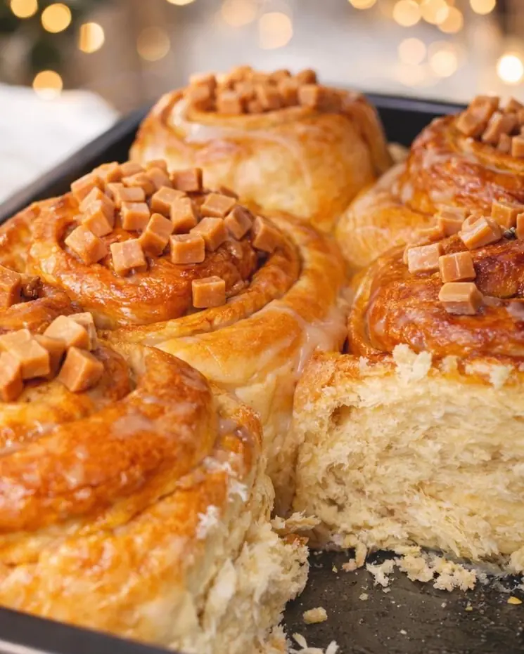 Rolls dorés couverts de cubes de caramel, l'un ouvert sur sa mie filante