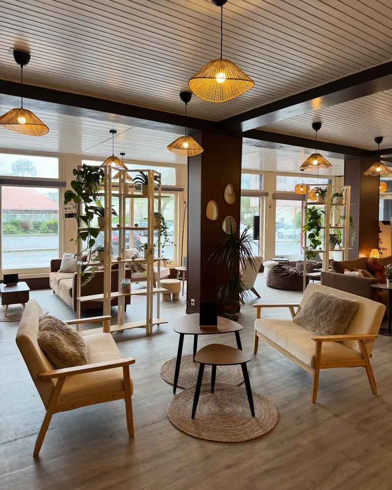 Le salon de Roll in Love : canapé, fauteuils clairs et suspensions en osier