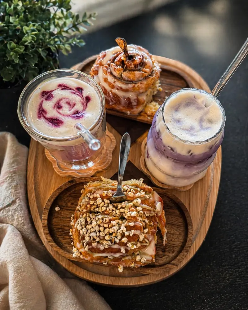 Plateau en bois : deux ubé lattes violets et deux rolls glacés aux éclats de noisette