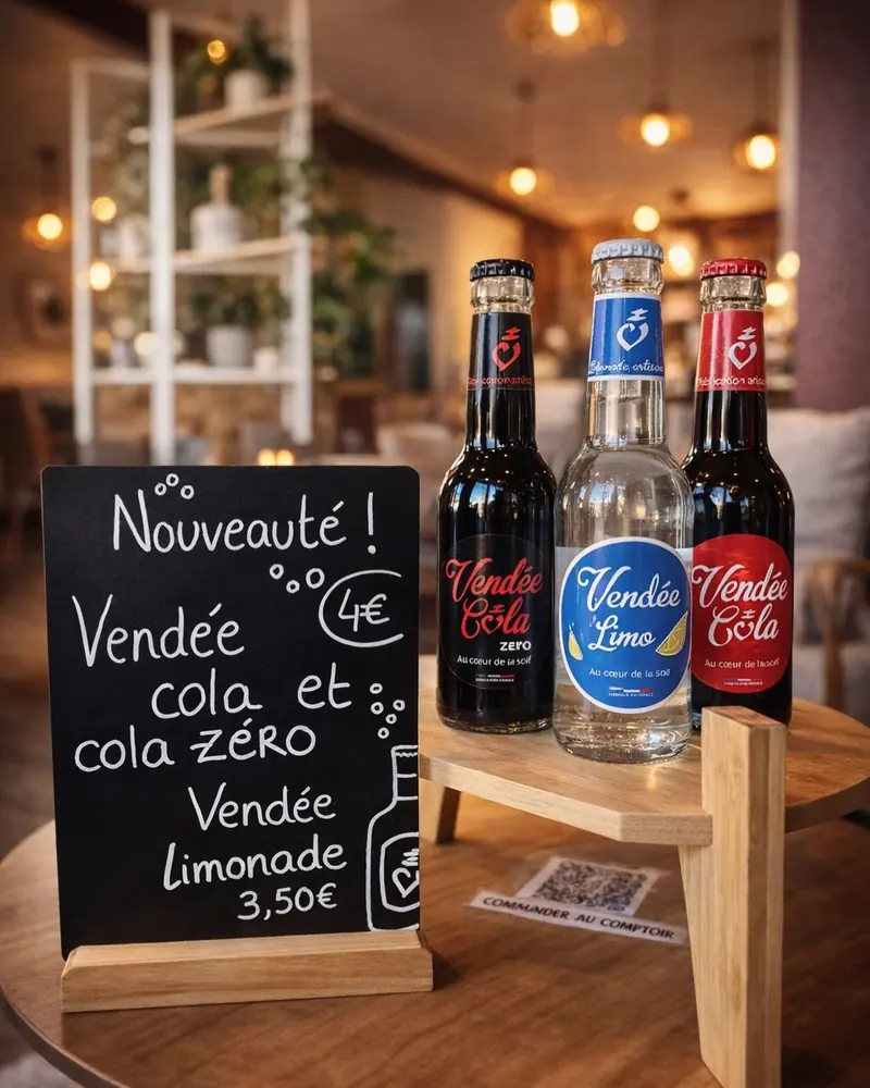 Ardoise annonçant le Vendée cola et la Vendée limonade, à côté des bouteilles en verre